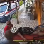 Leesett a hordágyról egy nő, miközben a mentősök a kocsiba próbálták betenni